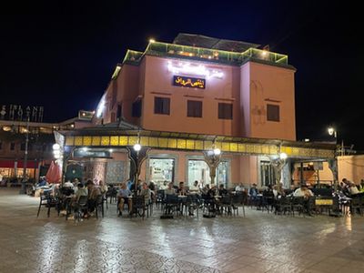 ジャマエルフナ広場入口周辺カフェ<br>(左に小さくホテルイスラーンが見える)<br>※現地パートナー提供